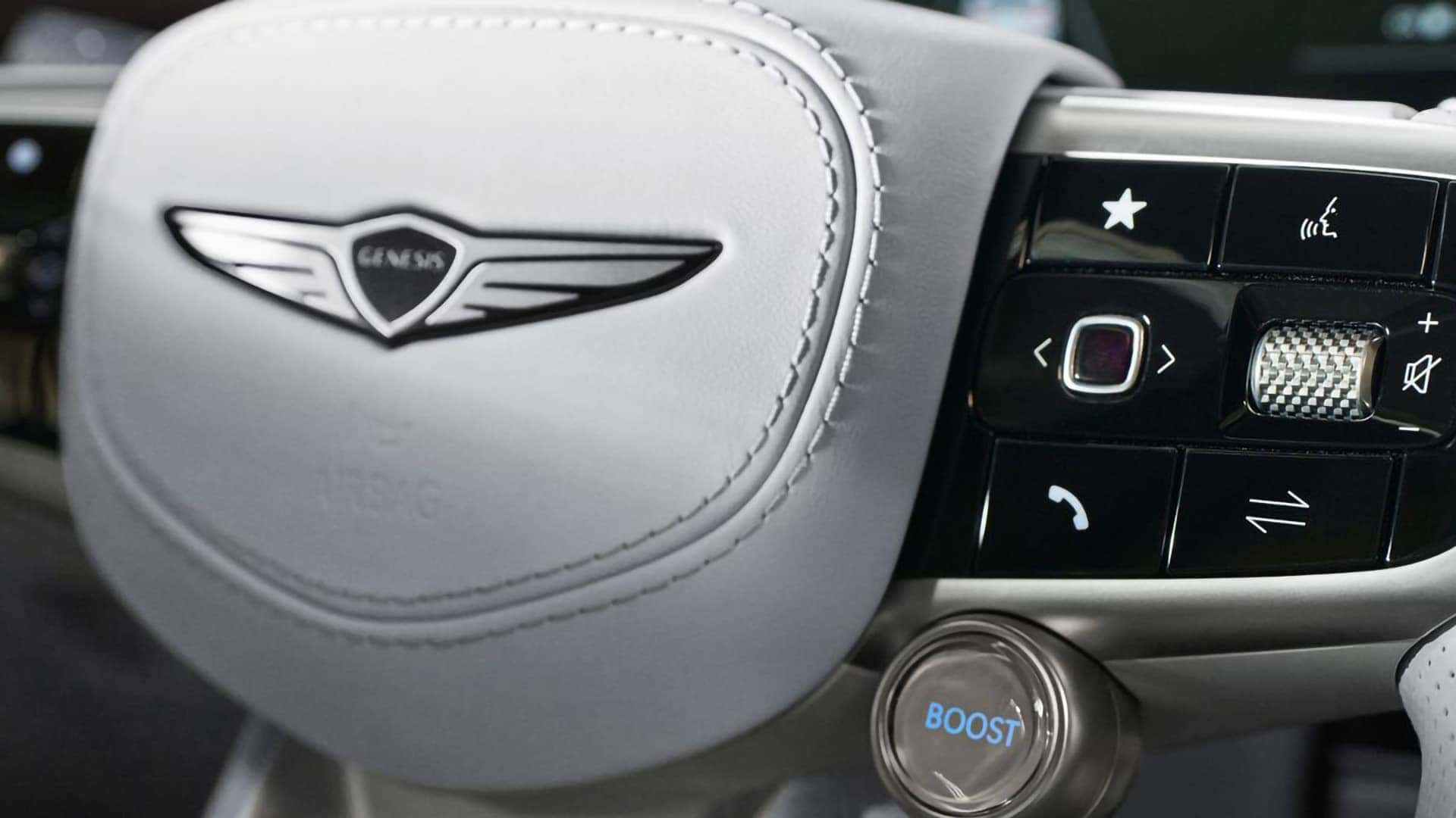 Close-up of the 2026 Genesis Electrified GV70 steering wheel controls and illuminated Boost Mode button