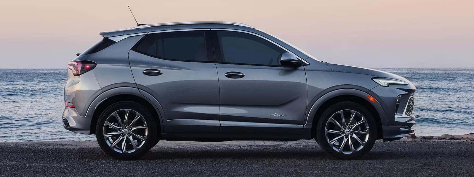 Gray 2026 Buick Encore GX Avenir in side profile beside the ocean