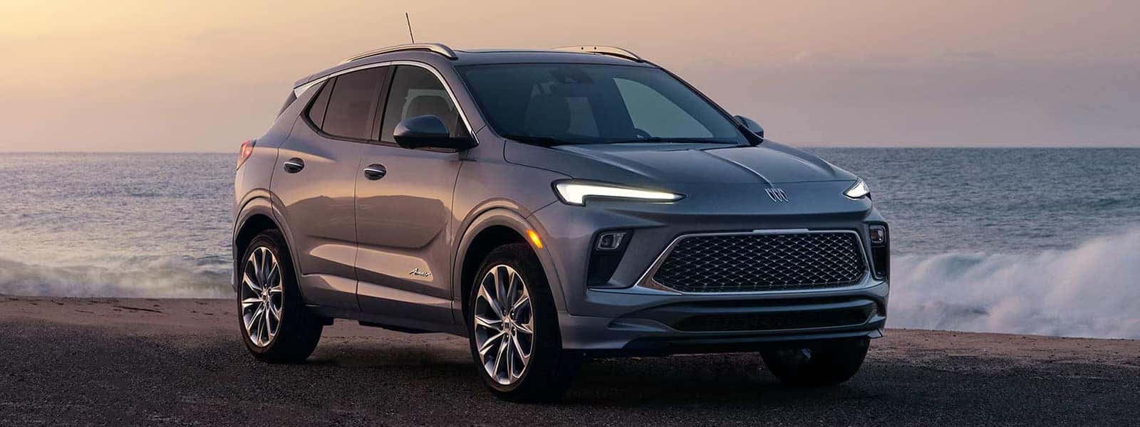 Gray 2026 Buick Encore GX Avenir parked beside the ocean at sunset