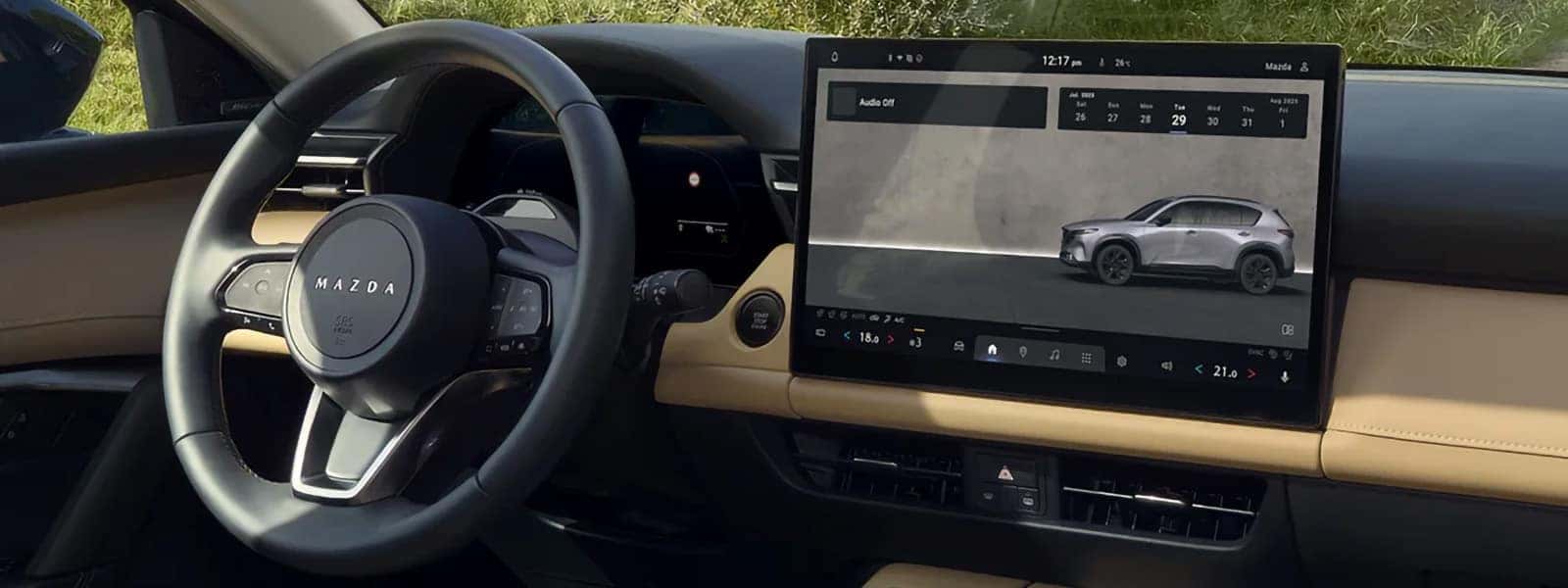 2026 Mazda CX-5 interior with steering wheel, digital gauge cluster, and large center touchscreen