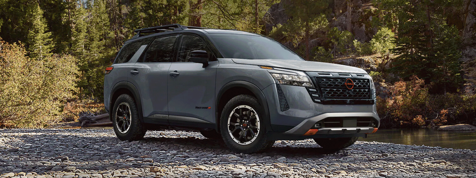2026 Nissan Pathfinder Rock Creek parked beside a wooded stream