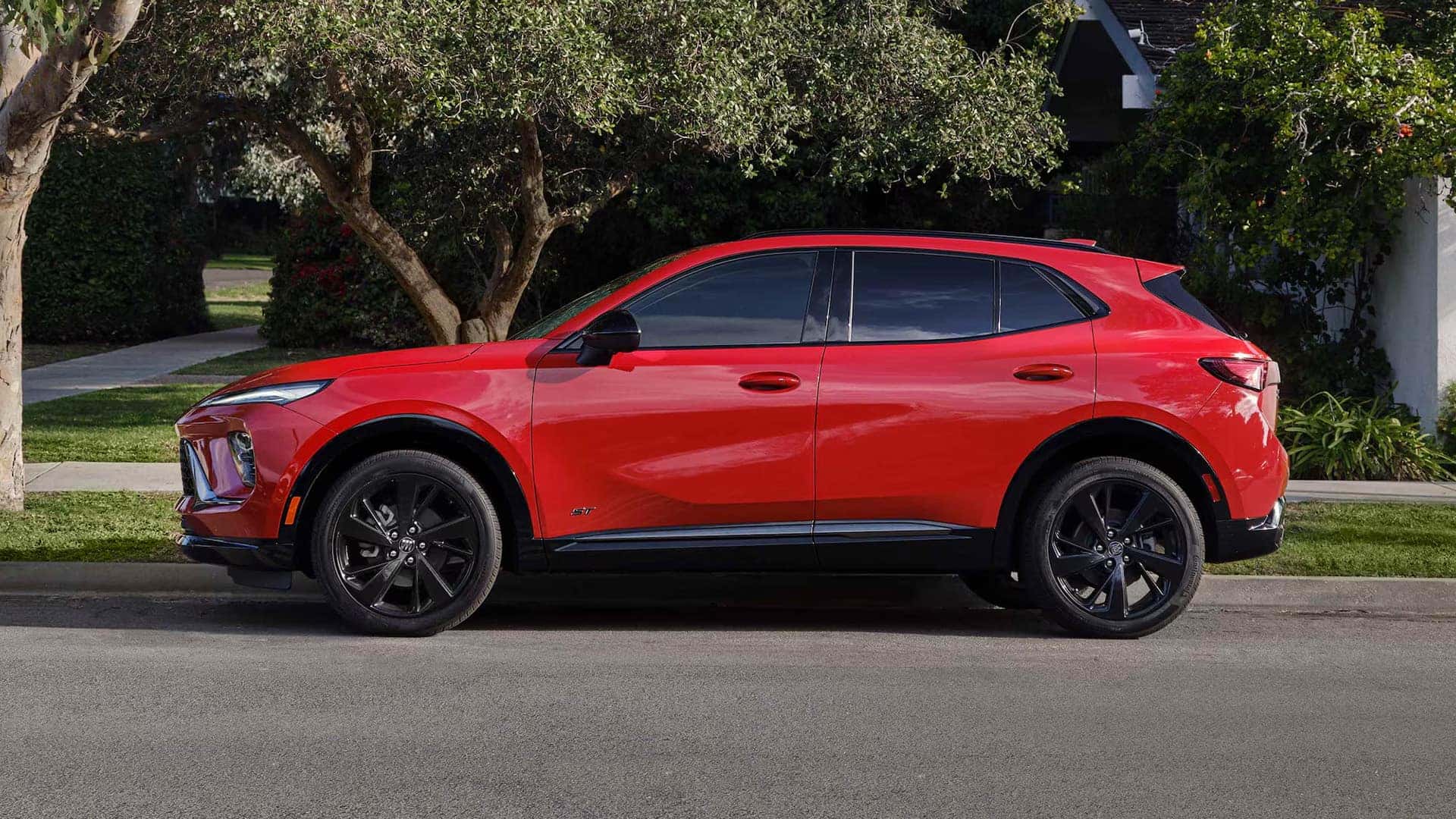 Side profile of a red 2026 Buick Envision Sport Touring with black alloy wheels