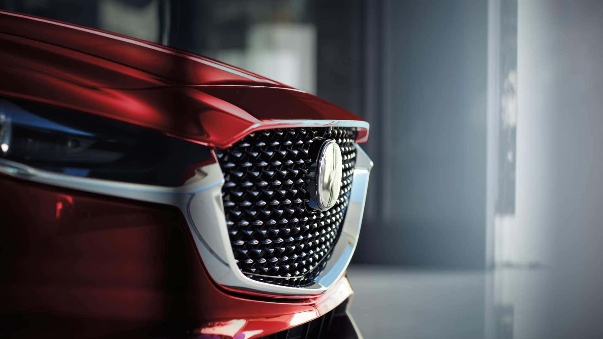 Close-up of the 2026 Mazda CX-30 black mesh grille, Mazda emblem, and chrome trim