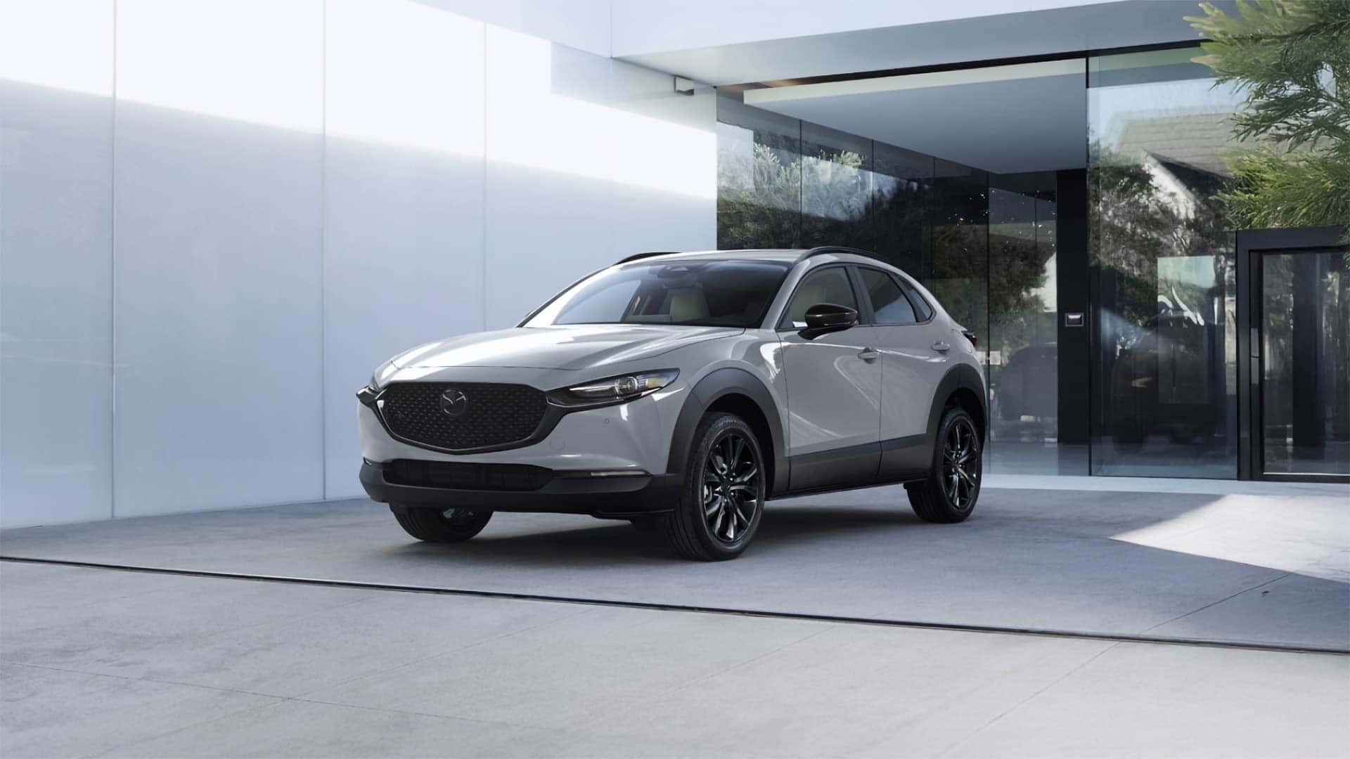 White 2026 Mazda CX-30 with black wheels parked outside a modern building