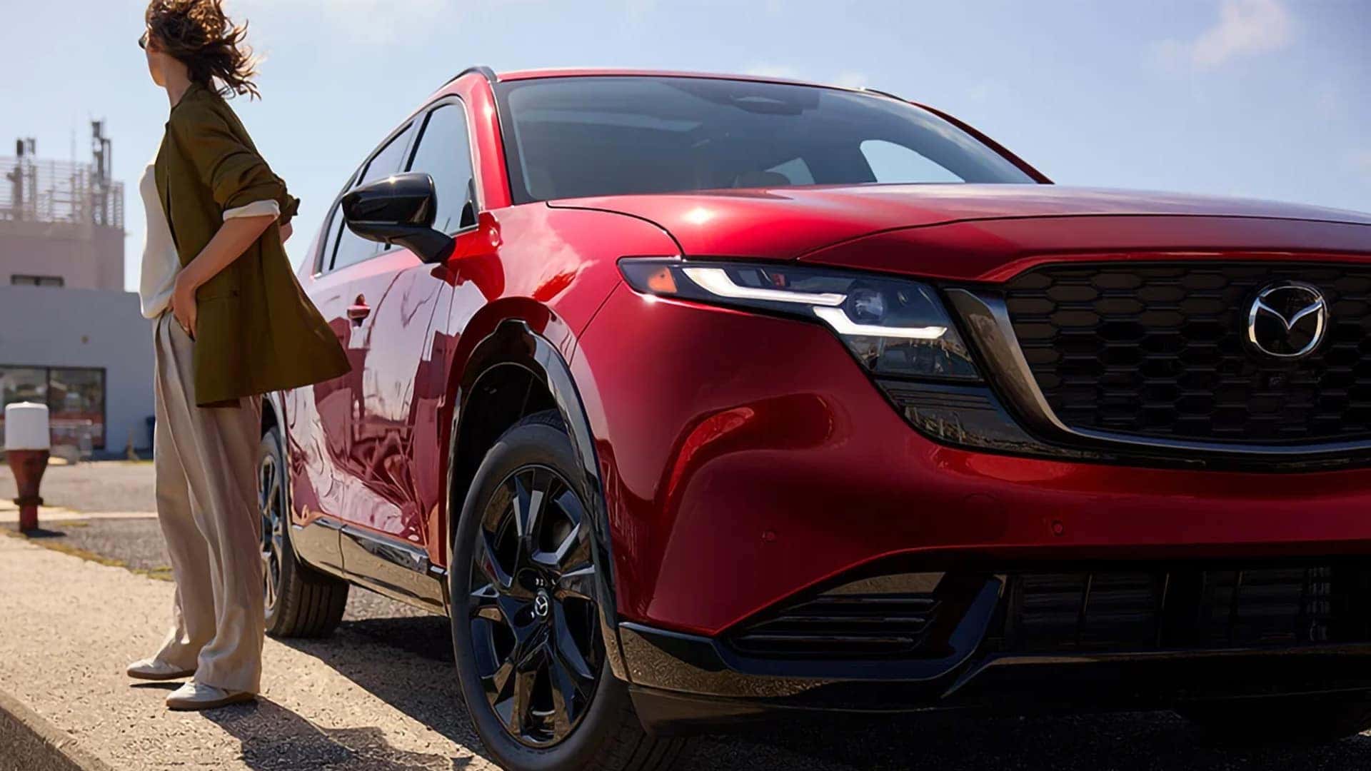 Front view of a red 2026 Mazda CX-5 showing its black grille, Mazda emblem, and sculpted hood