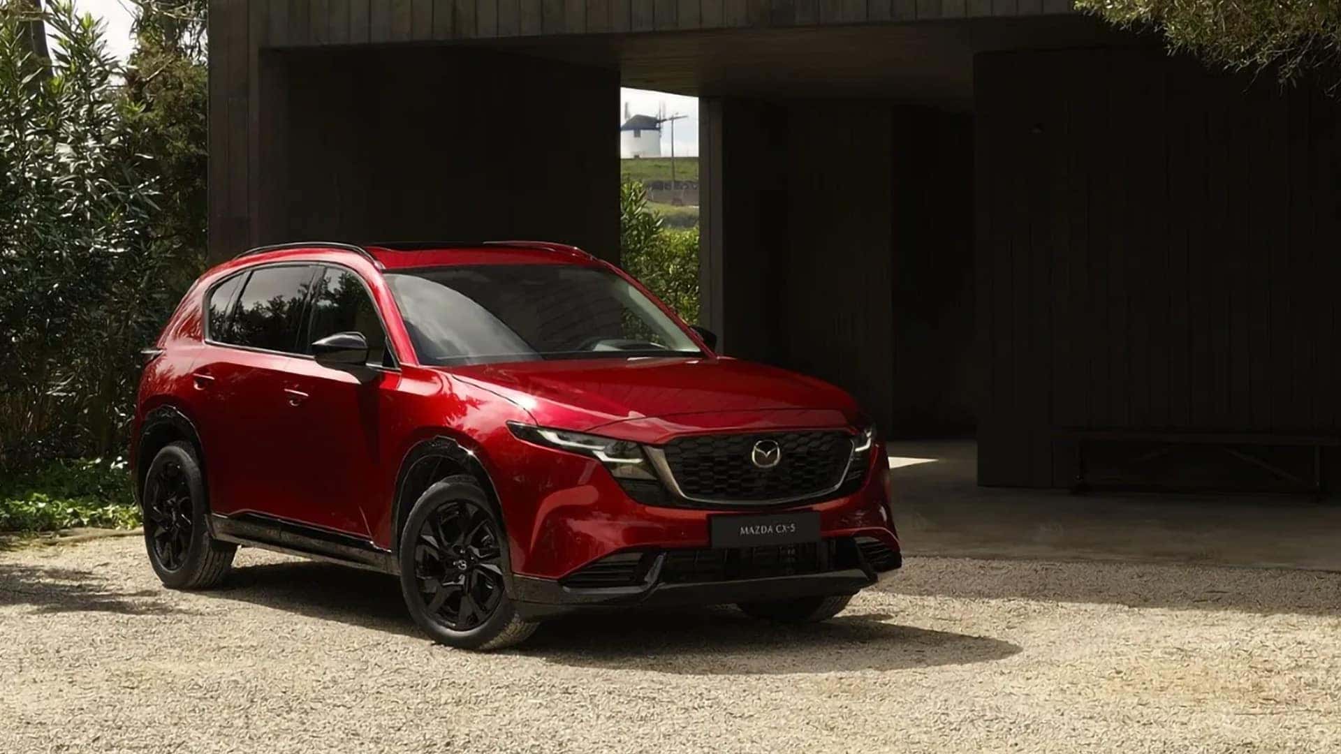 Red 2026 Mazda CX-5 with black alloy wheels parked outside a modern home