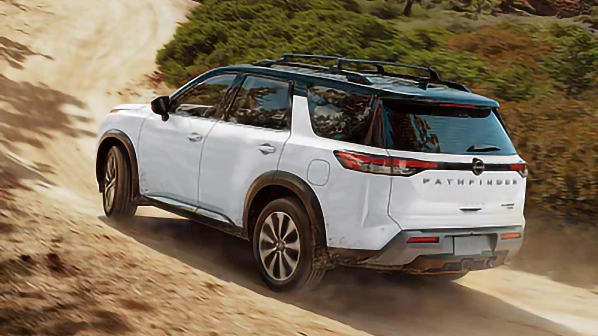 White 2026 Nissan Pathfinder driving on a winding dirt road through a wooded area