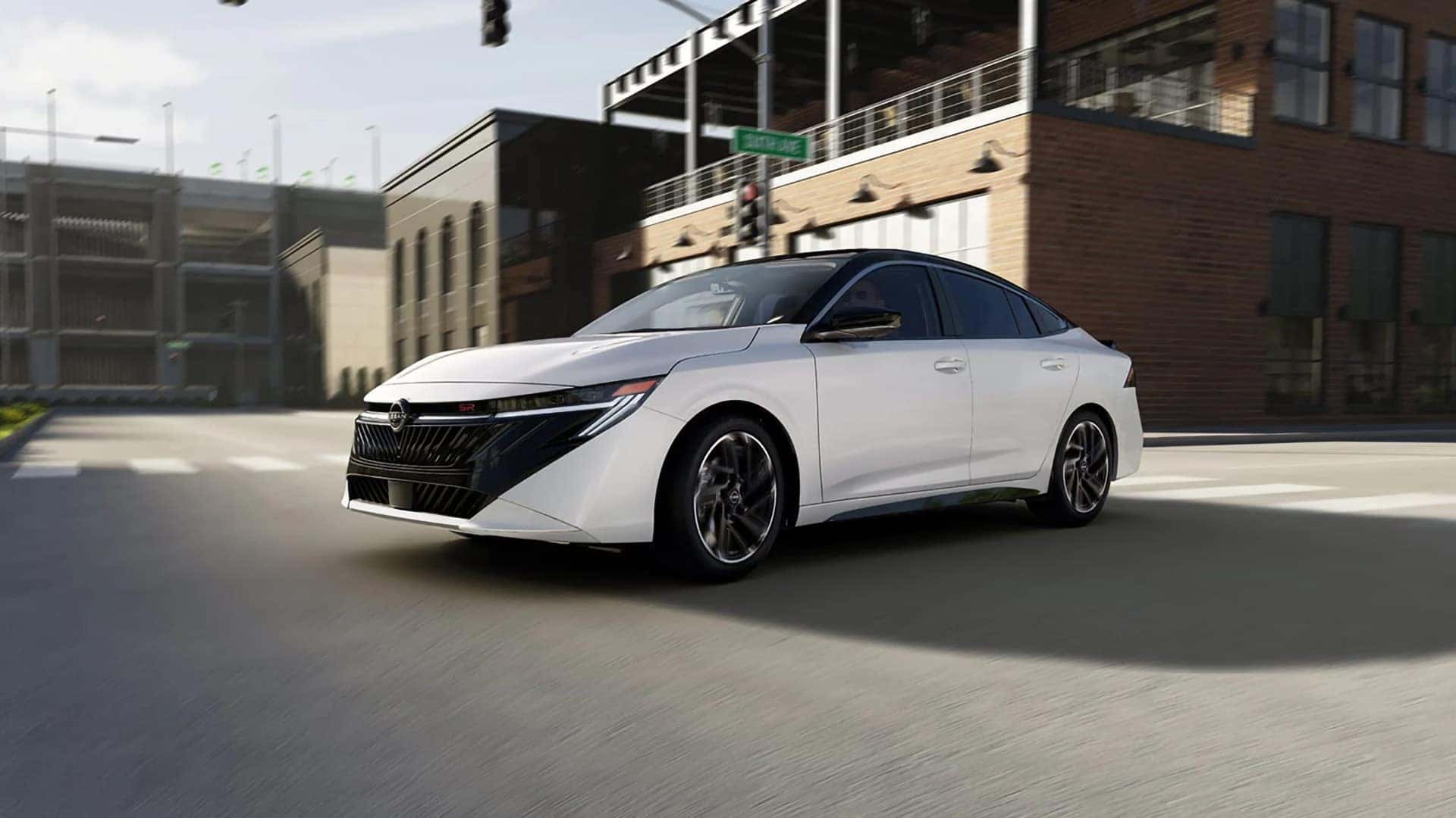 White 2026 Nissan Sentra SR driving through the city in a front three-quarter view.