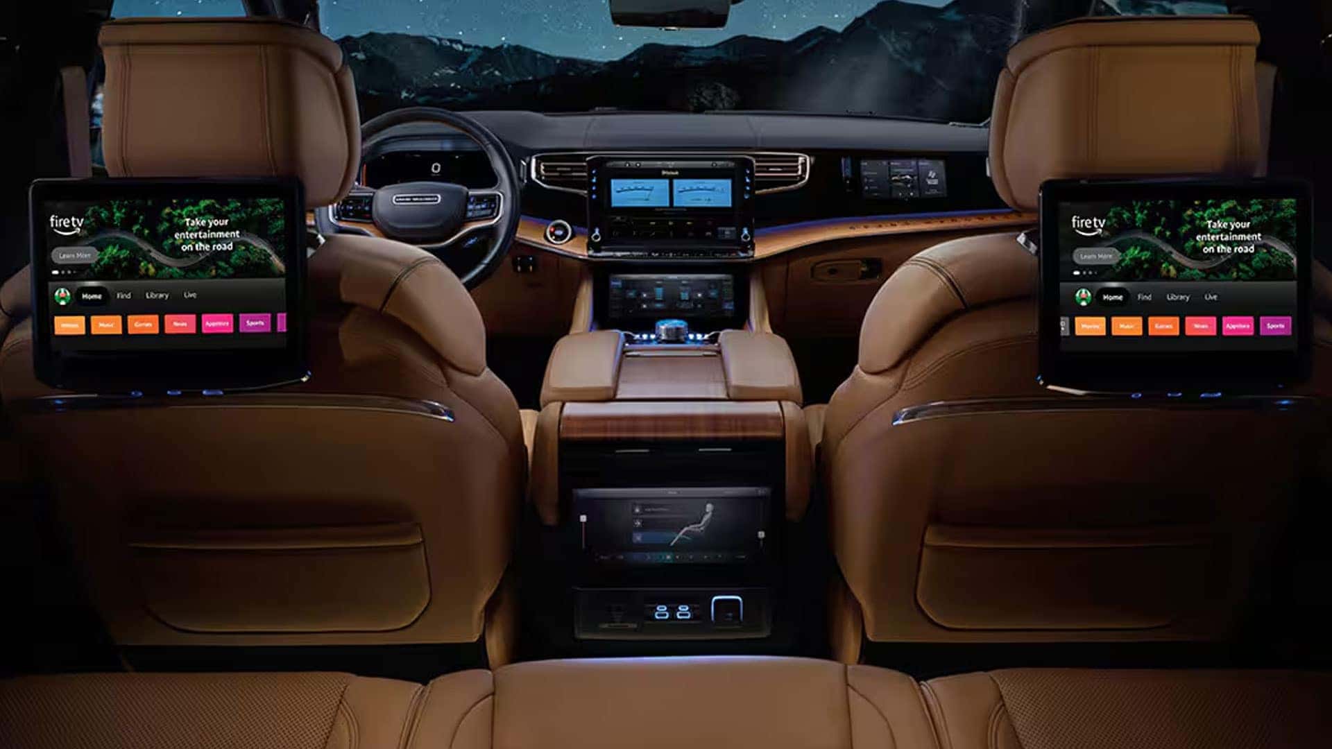2026 Jeep Grand Wagoneer rear cabin with two seatback screens, dashboard displays, and tan leather seating.