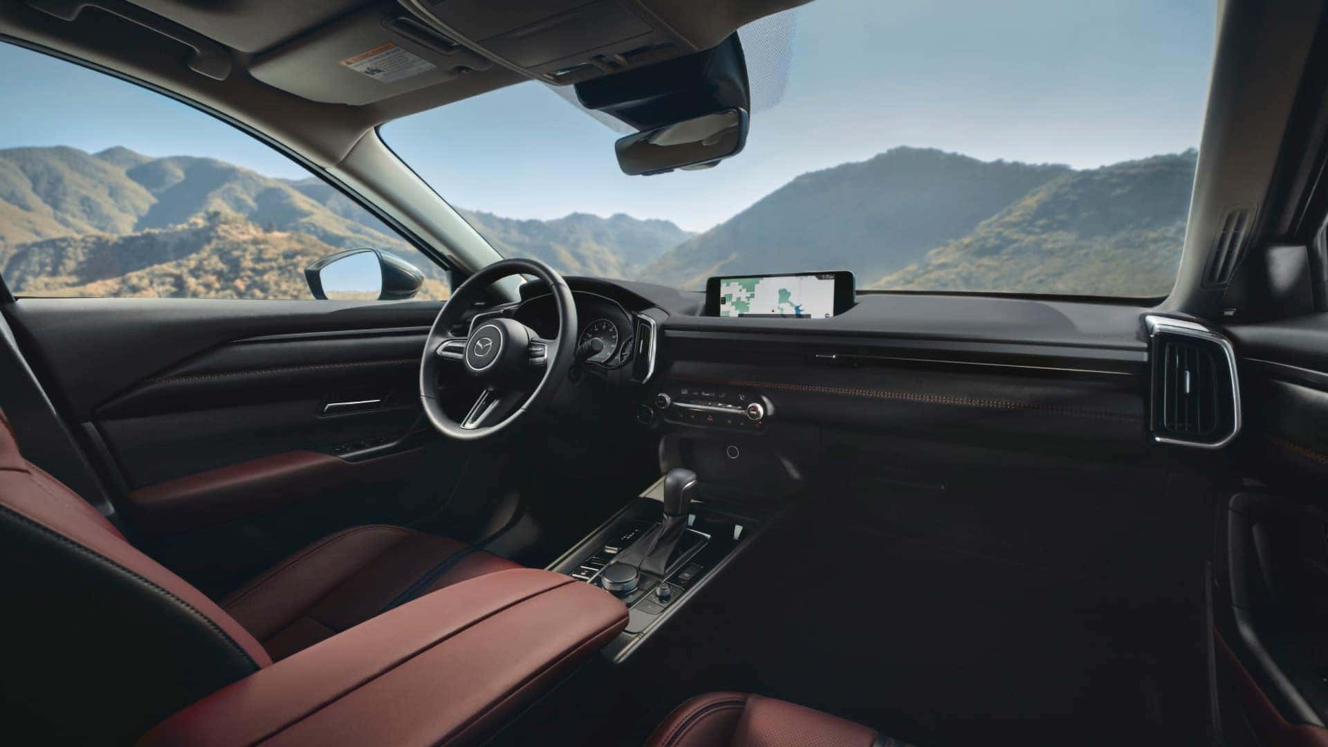 2026 Mazda CX-50 Hybrid cabin with red leather seats, infotainment display, and mountain views