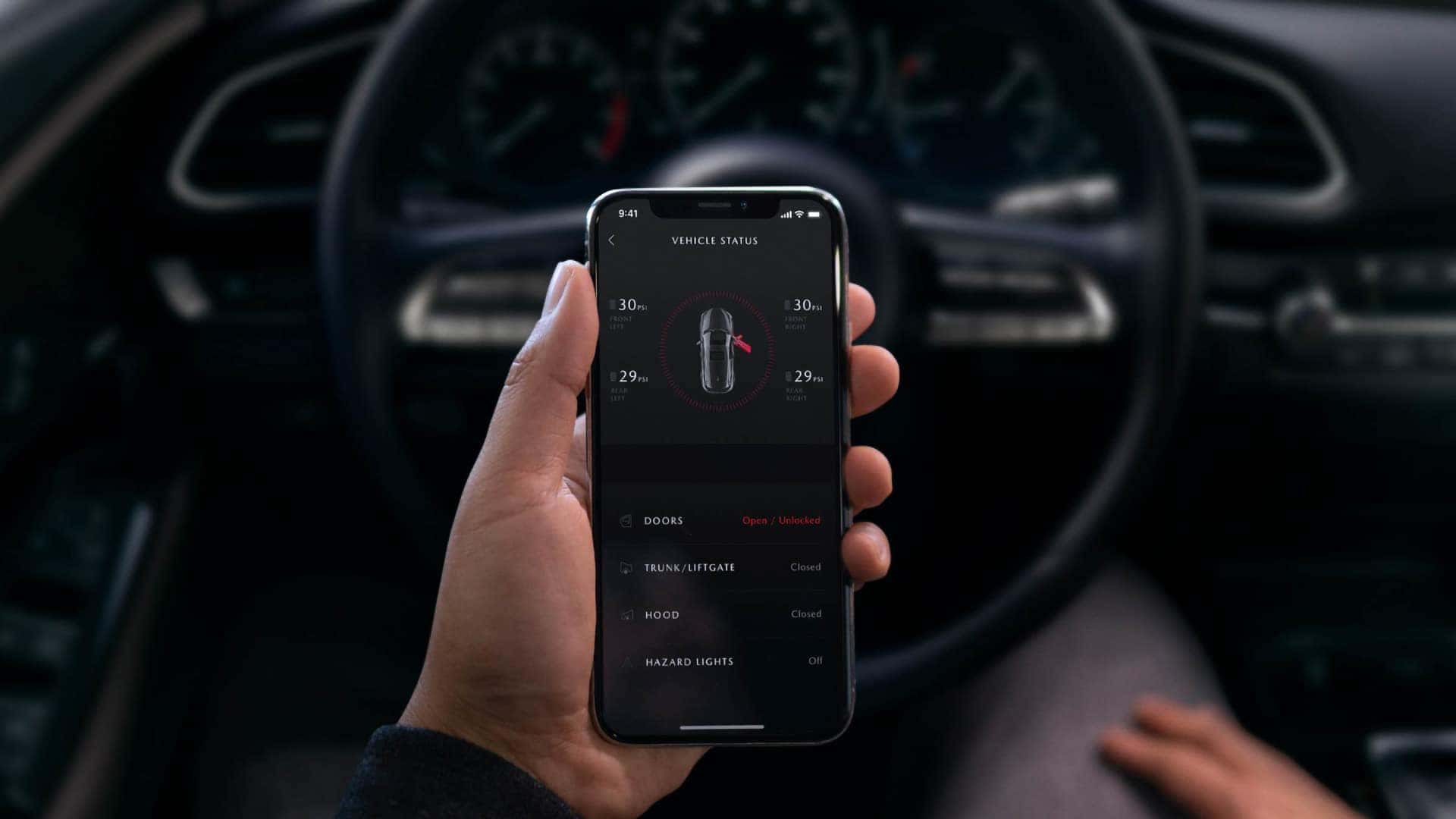 Driver using the MyMazda App on a smartphone inside the 2026 Mazda CX-30