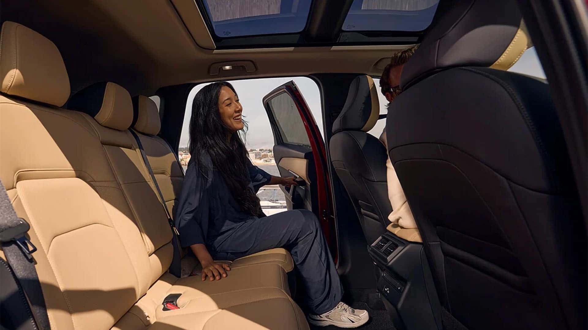 Passenger seated in the spacious second row of a 2026 Mazda CX-5 beneath the panoramic moonroof