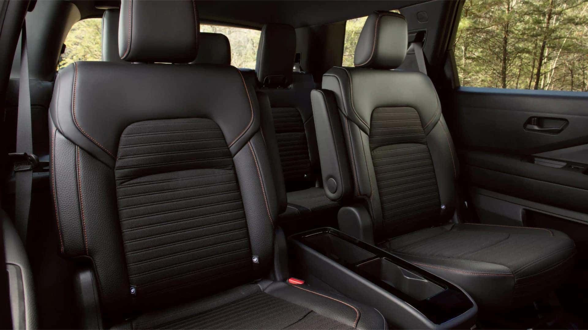 2026 Nissan Pathfinder second-row captain’s chairs with black upholstery, orange stitching, and center storage console