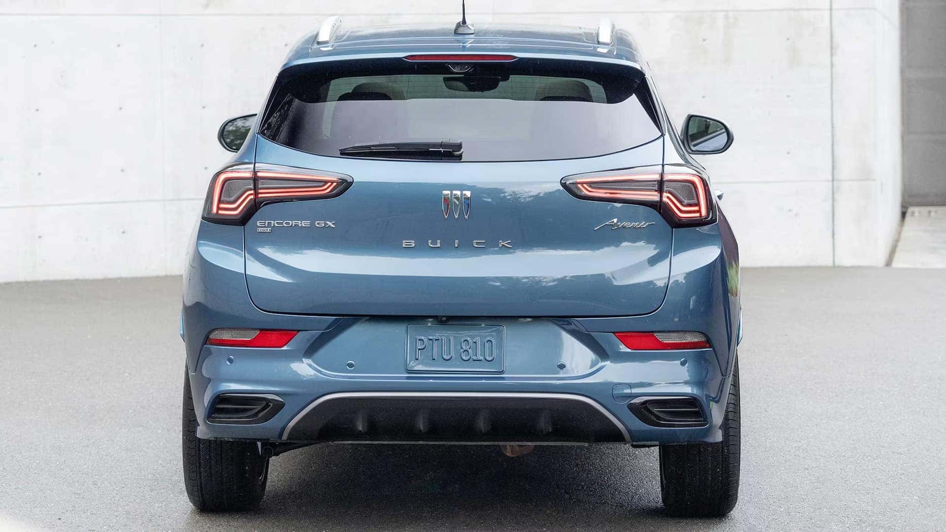 Rear view of a blue 2026 Buick Encore GX Avenir with illuminated taillamps and liftgate badging