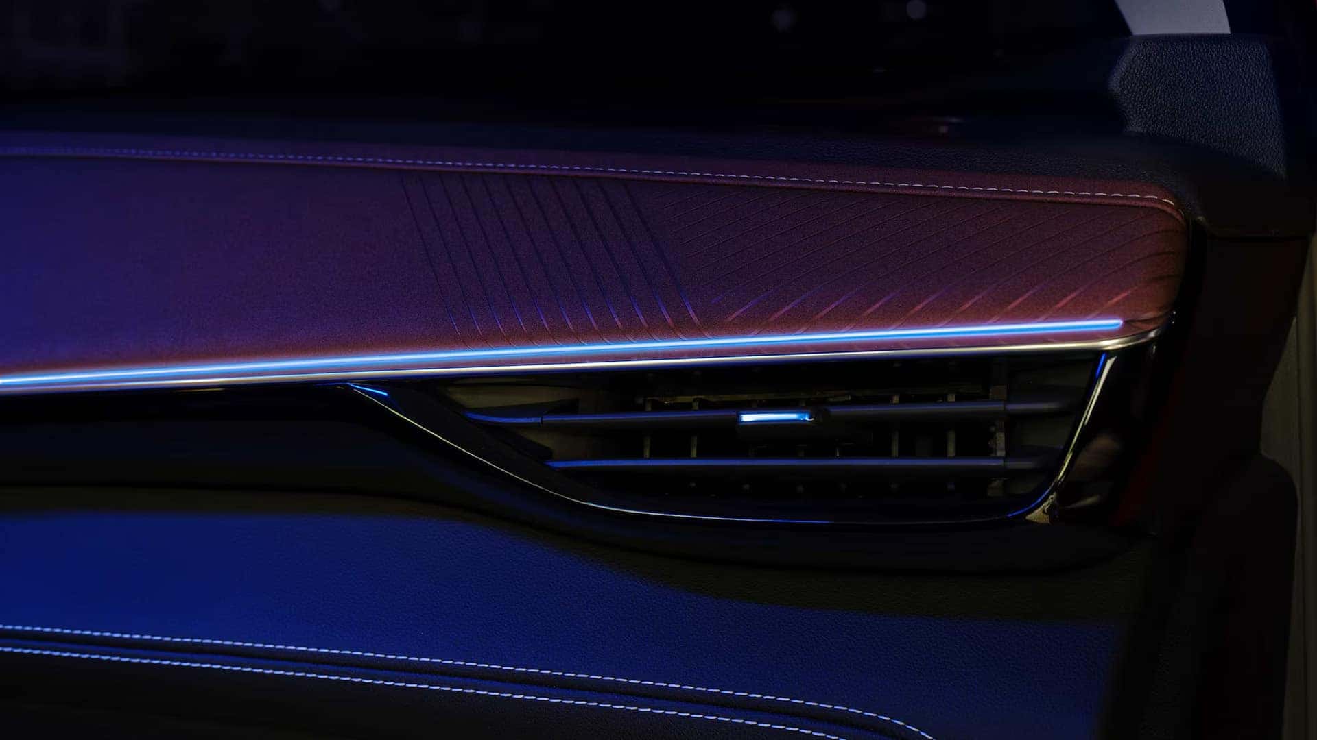 Blue ambient lighting illuminating the dashboard trim and air vent inside the 2026 Buick Envision