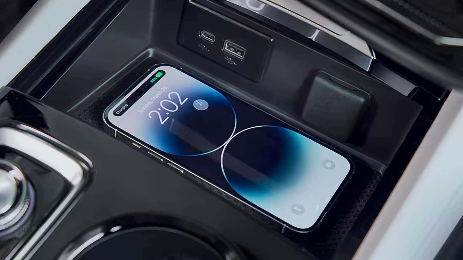 Smartphone charging wirelessly beside USB ports in the 2026 Buick Envision center console