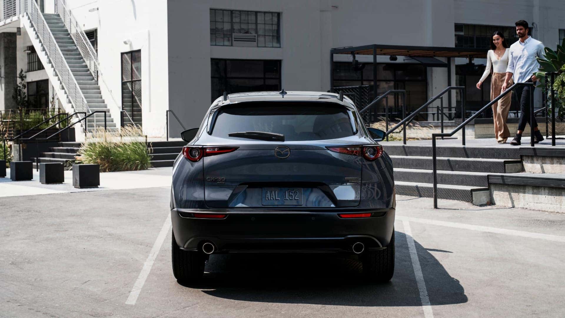 Rear view of a gray 2026 Mazda CX-30 featuring circular taillights and dual exhaust outlets
