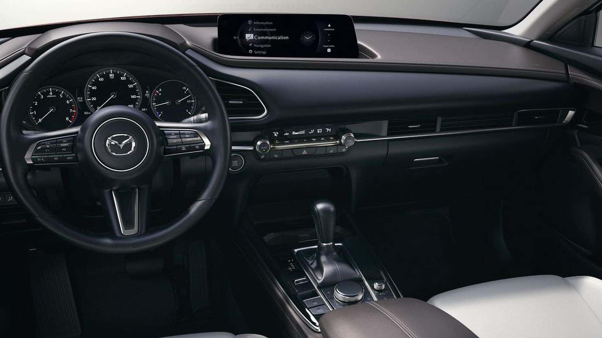 Driver view of the 2026 Mazda CX-30 steering wheel, instrument cluster, center display, and climate controls