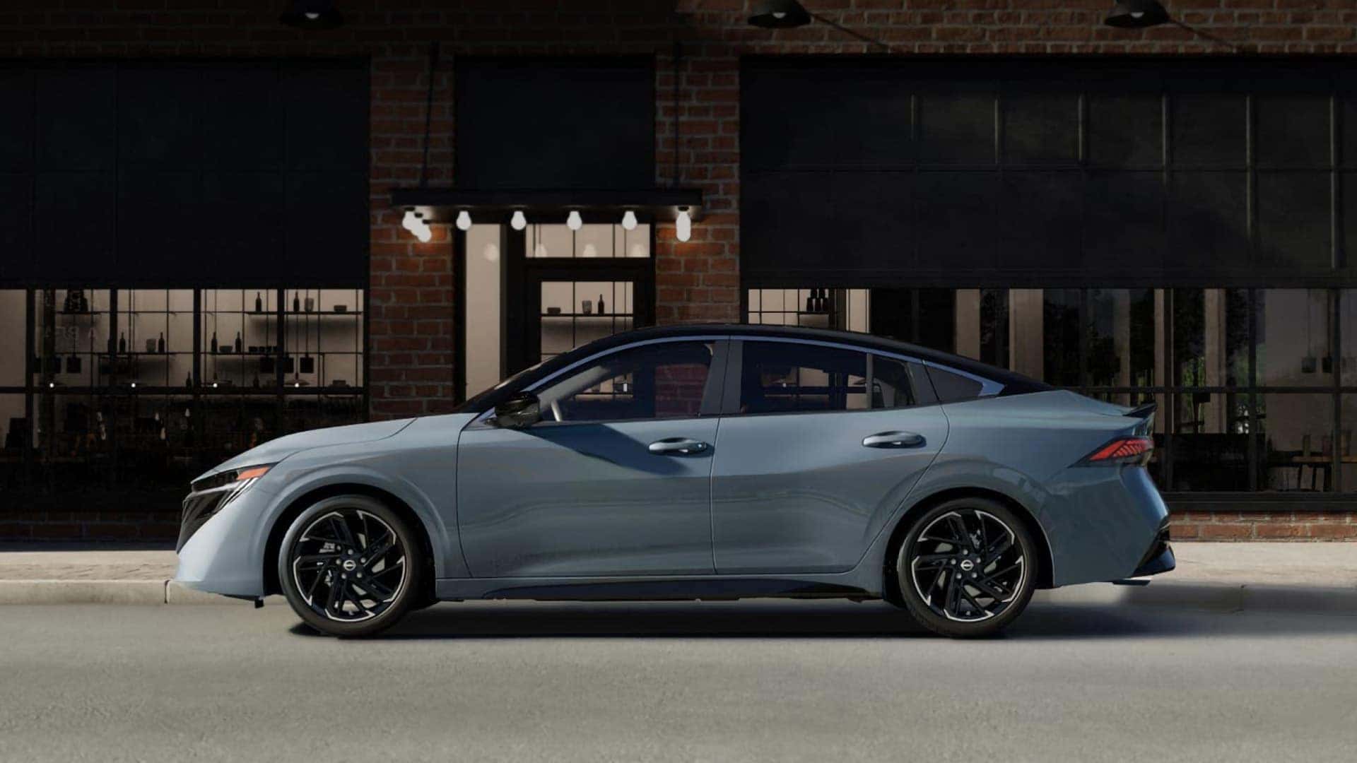 Side profile of a blue-gray 2026 Nissan Sentra showing its sculpted body lines and contrasting black roof