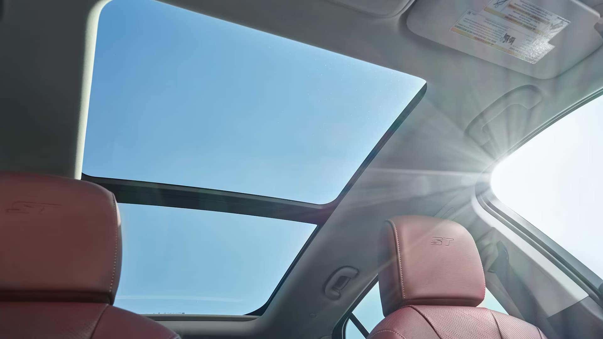 Panoramic moonroof above burgundy seating in the 2026 Buick Envision Sport Touring