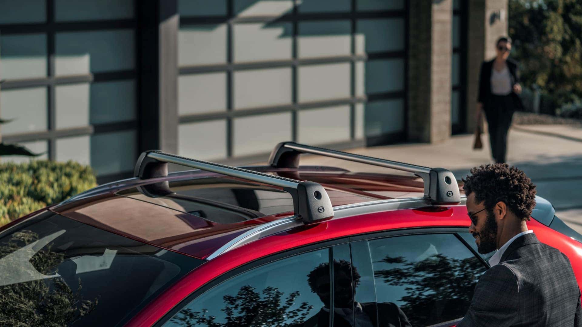 Red 2026 Mazda CX-30 with a glass moonroof and roof rack parked outside a modern building
