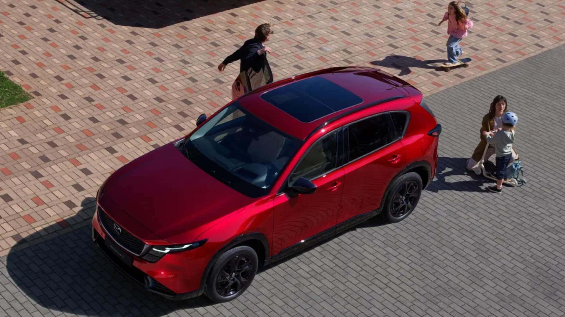Overhead view of a red 2026 Mazda CX-5 showing its panoramic moonroof and black alloy wheels