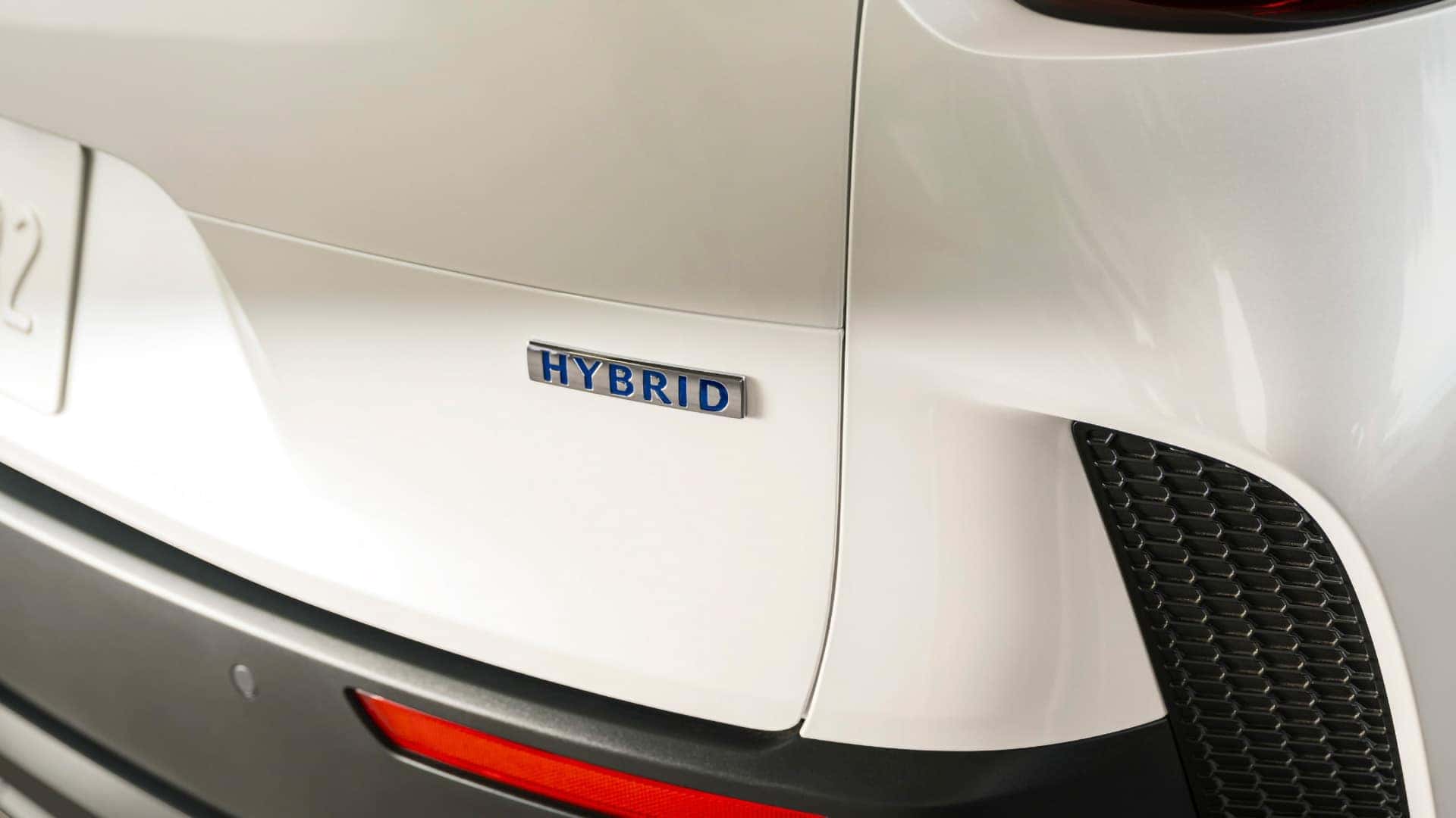 Close-up of the hybrid badge on the rear of a white 2026 Mazda CX-50 Hybrid