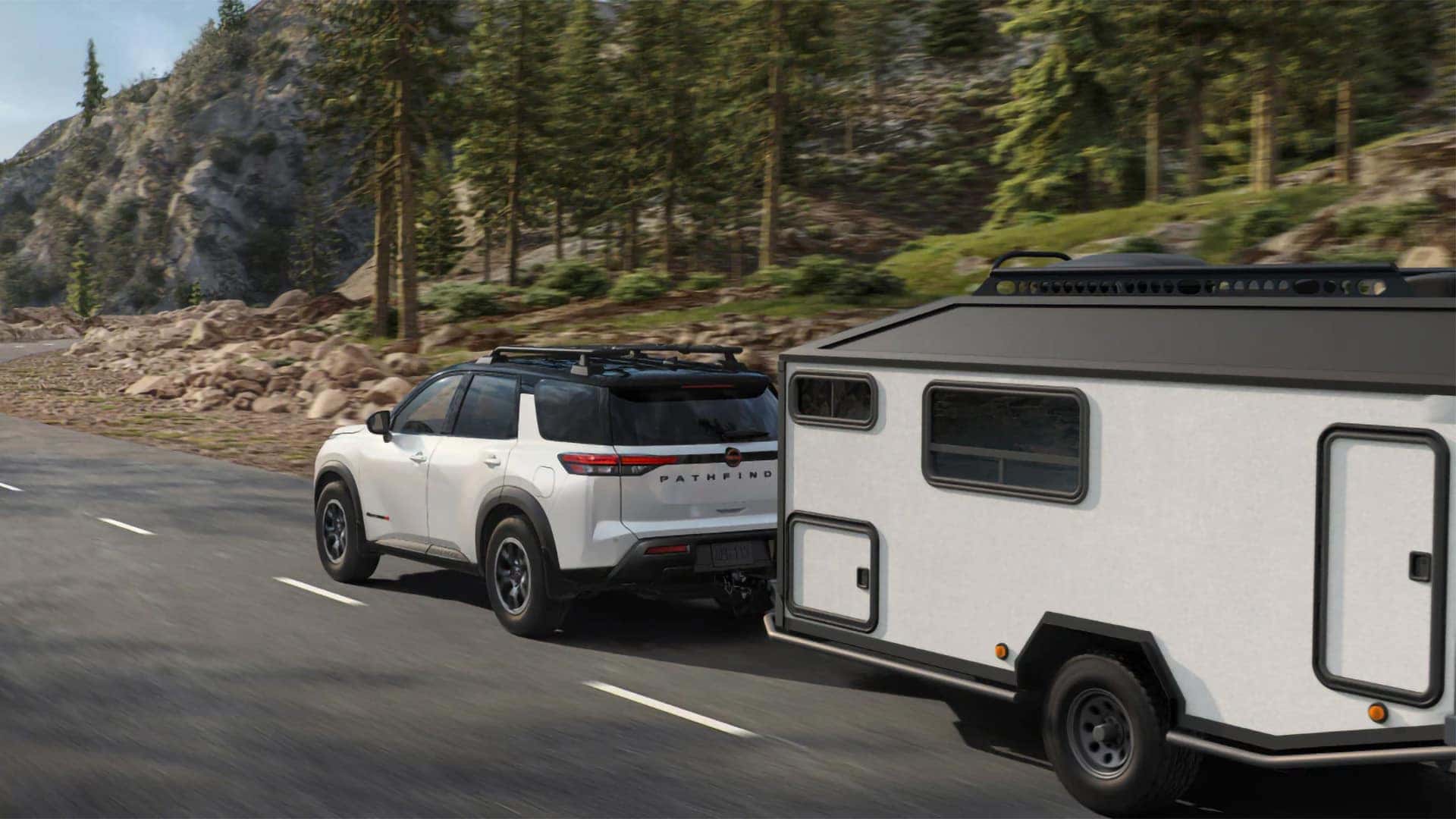 White 2026 Nissan Pathfinder towing a travel trailer along a mountain road