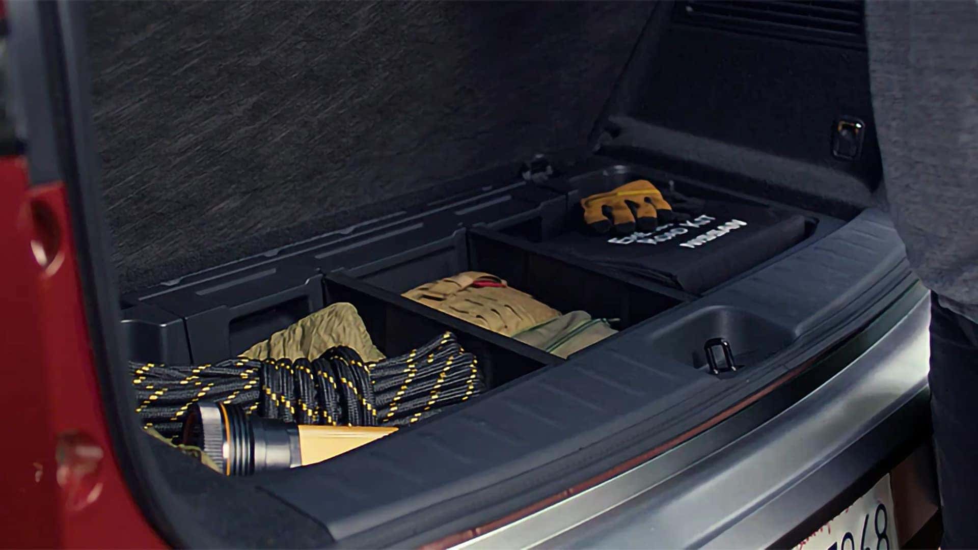 2026 Nissan Pathfinder underfloor cargo storage holding gloves, a flashlight, rope, and other gear