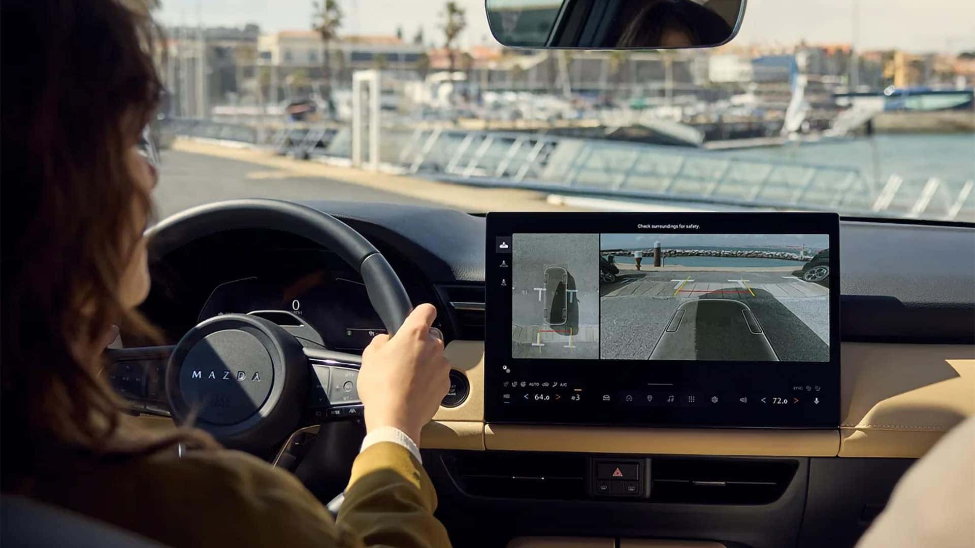 Driver viewing rear camera and overhead parking views on the 2026 Mazda CX-5 touchscreen