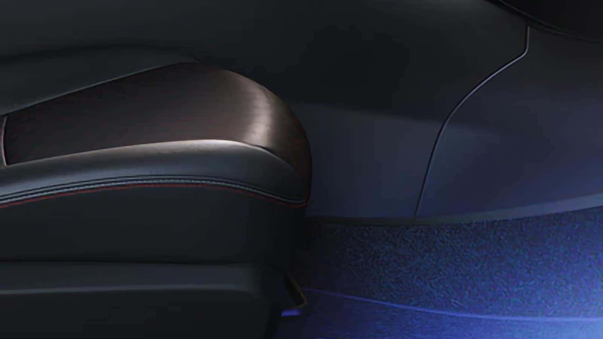 Blue ambient lighting illuminating the front footwell of the 2026 Nissan Sentra interior