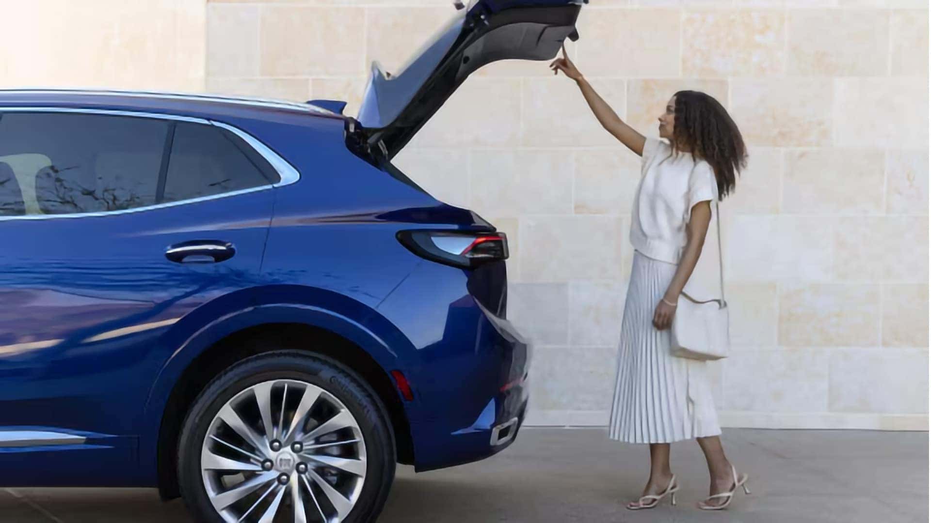 Woman opening the hands-free programmable power liftgate of a blue 2026 Buick Envision Avenir