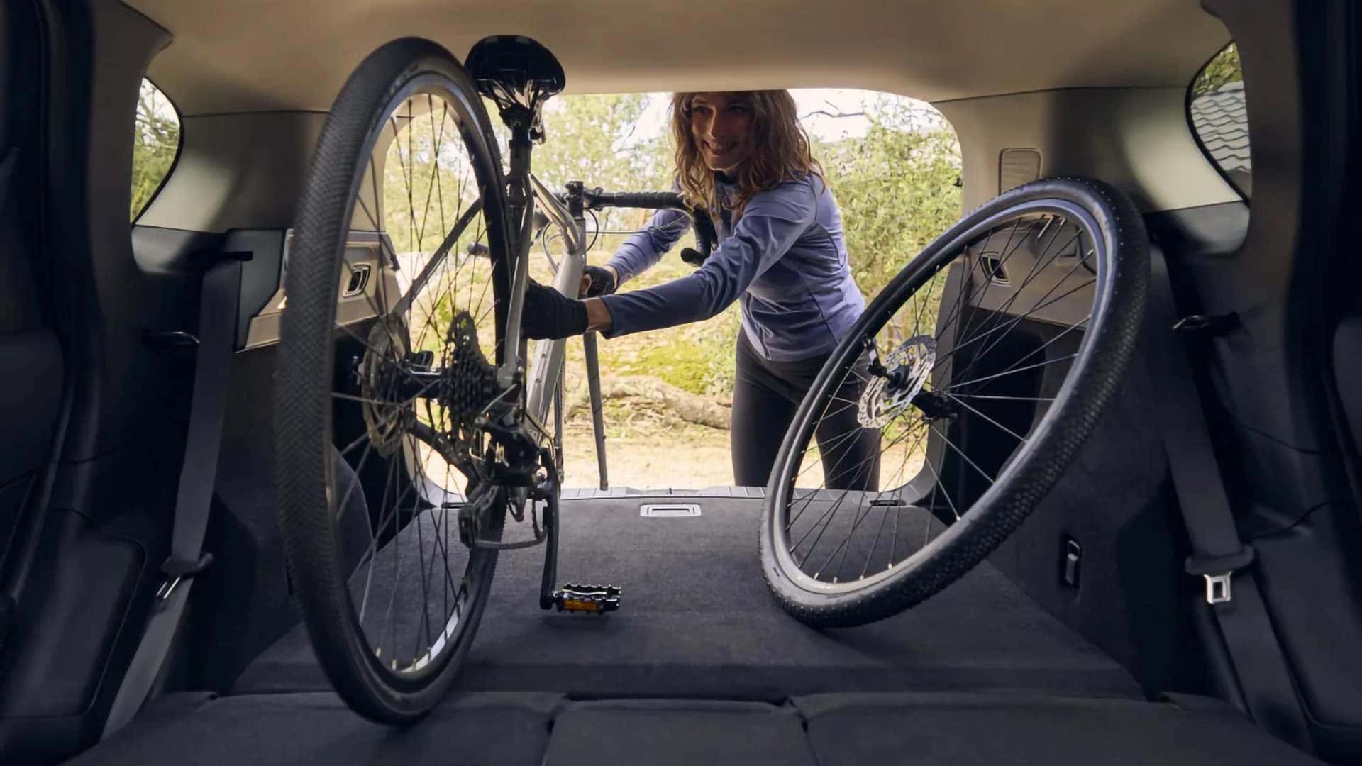 Cyclist loading a bicycle into the expanded cargo area of a 2026 Mazda CX-5
