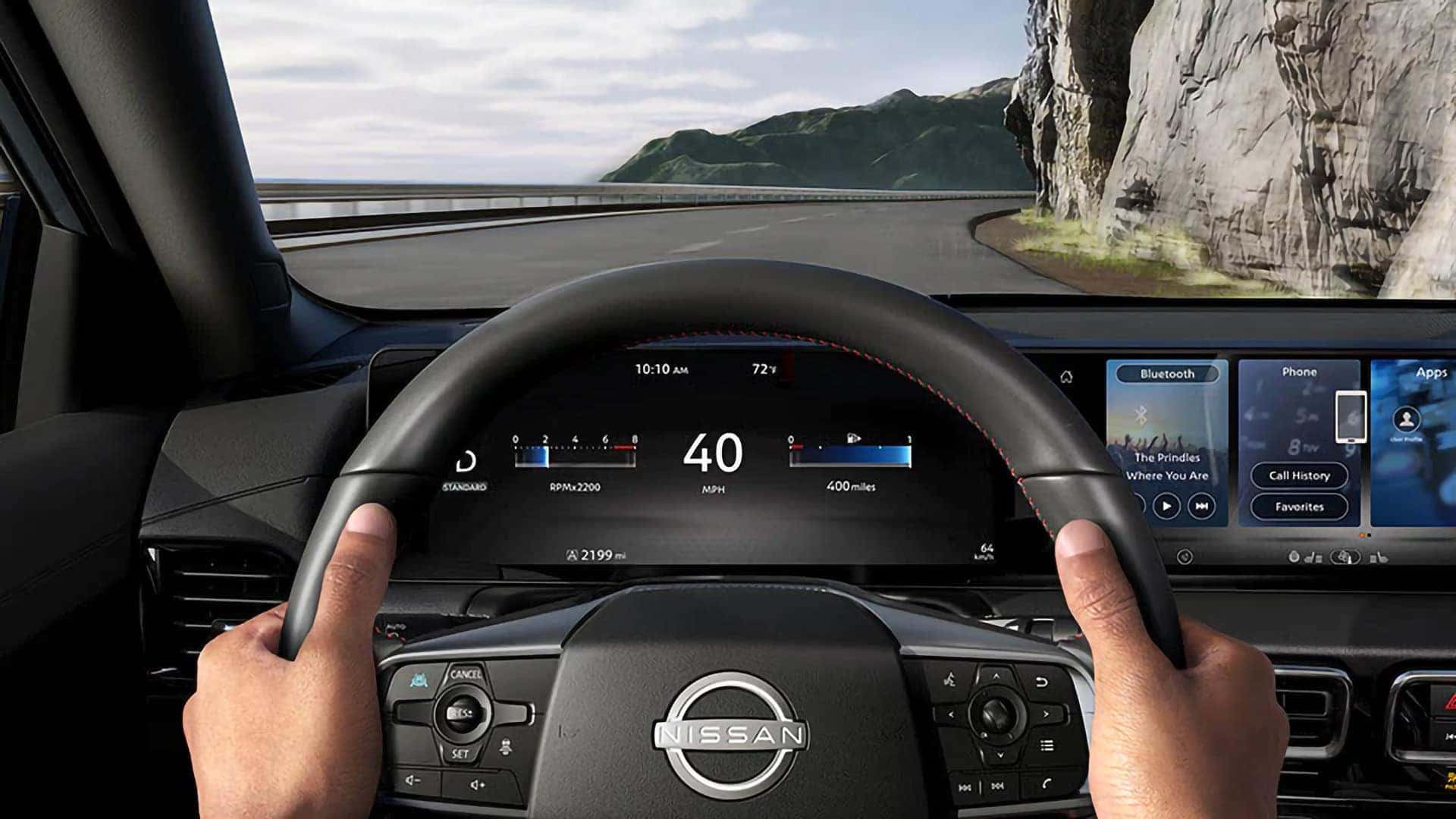 Driver view of the 2026 Nissan Sentra digital instrument cluster and infotainment display on a coastal road