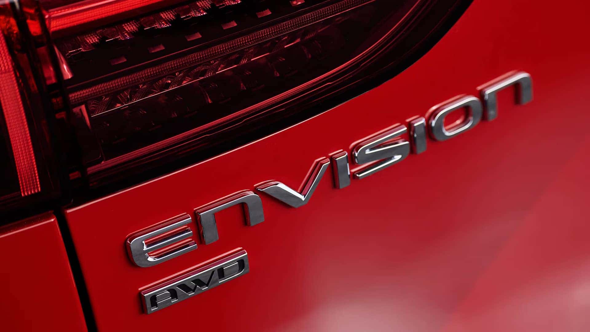 Close-up of Buick Envision and AWD badges beside the rear taillight