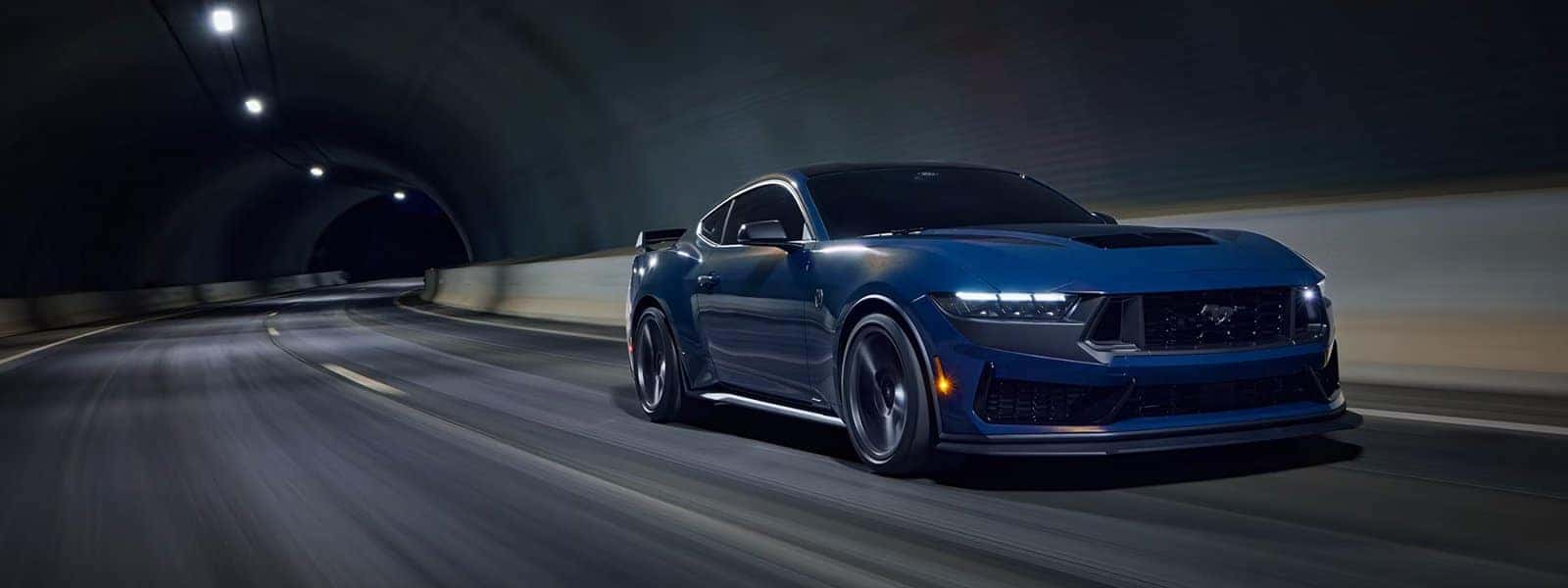 Blue 2026 Ford Mustang driving through a tunnel at night