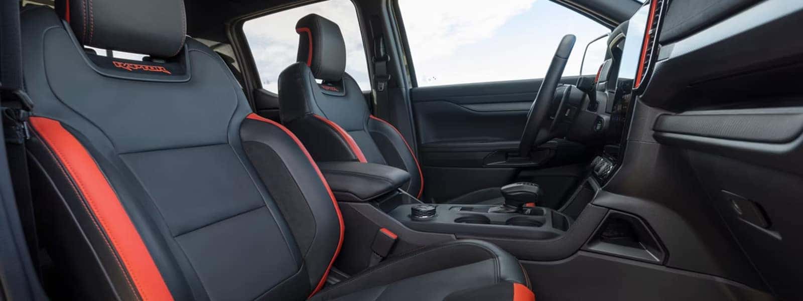 2026 Ford Ranger Raptor interior with black and red front seats, dashboard, and center console