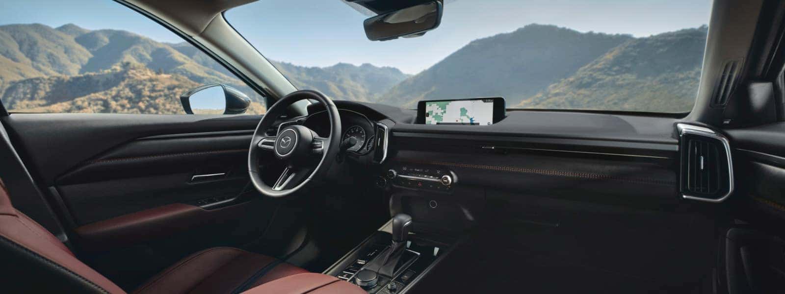 2026 Mazda CX-50 Hybrid interior with navigation display and mountain views through the windshield