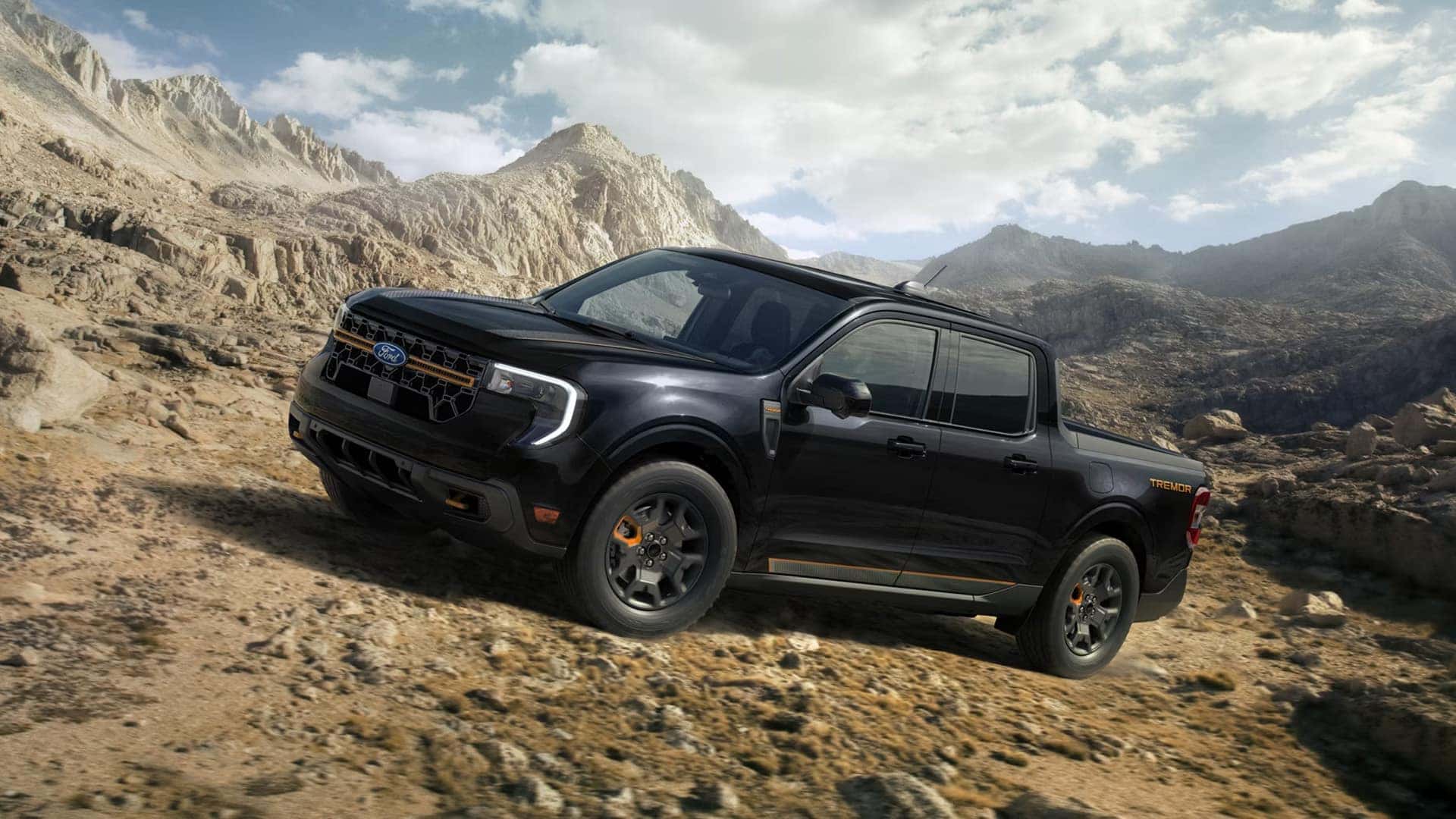 Black 2026 Ford Maverick Tremor driving across rocky mountain terrain