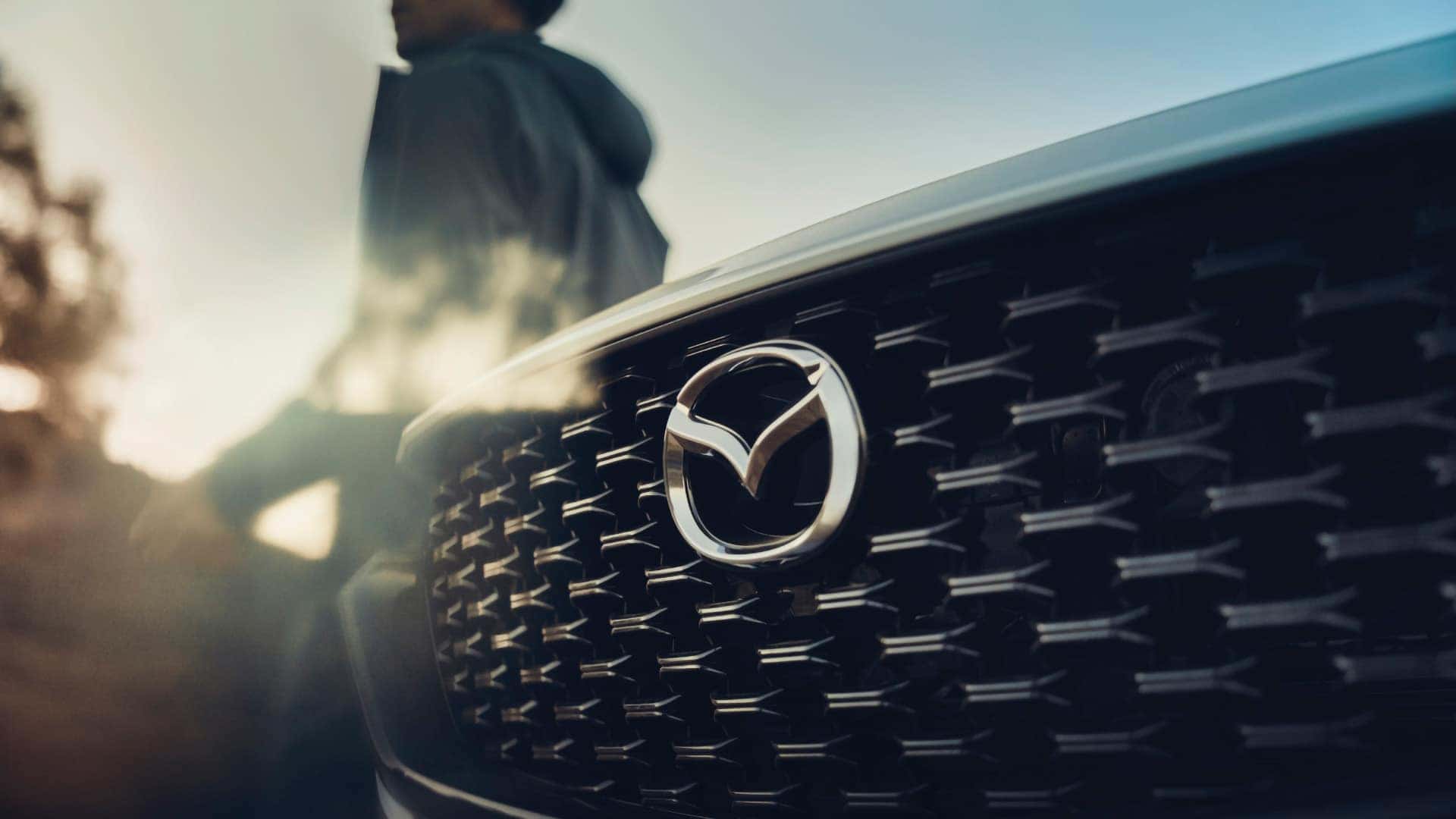 Close-up of the black grille and Mazda emblem on a 2026 Mazda CX-50 Hybrid