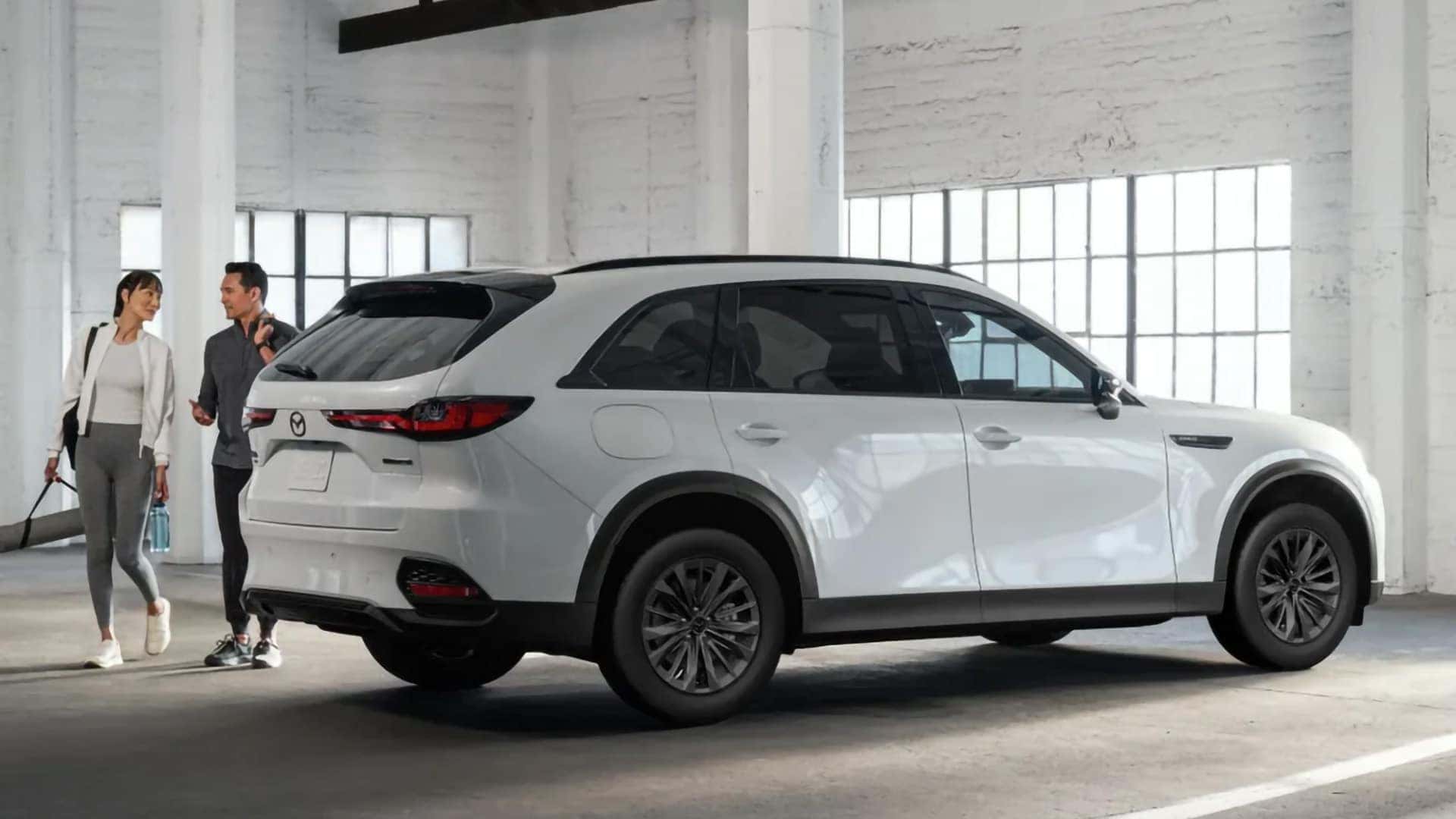 White 2026 Mazda CX-70 PHEV shown from the rear three-quarter angle inside a bright studio