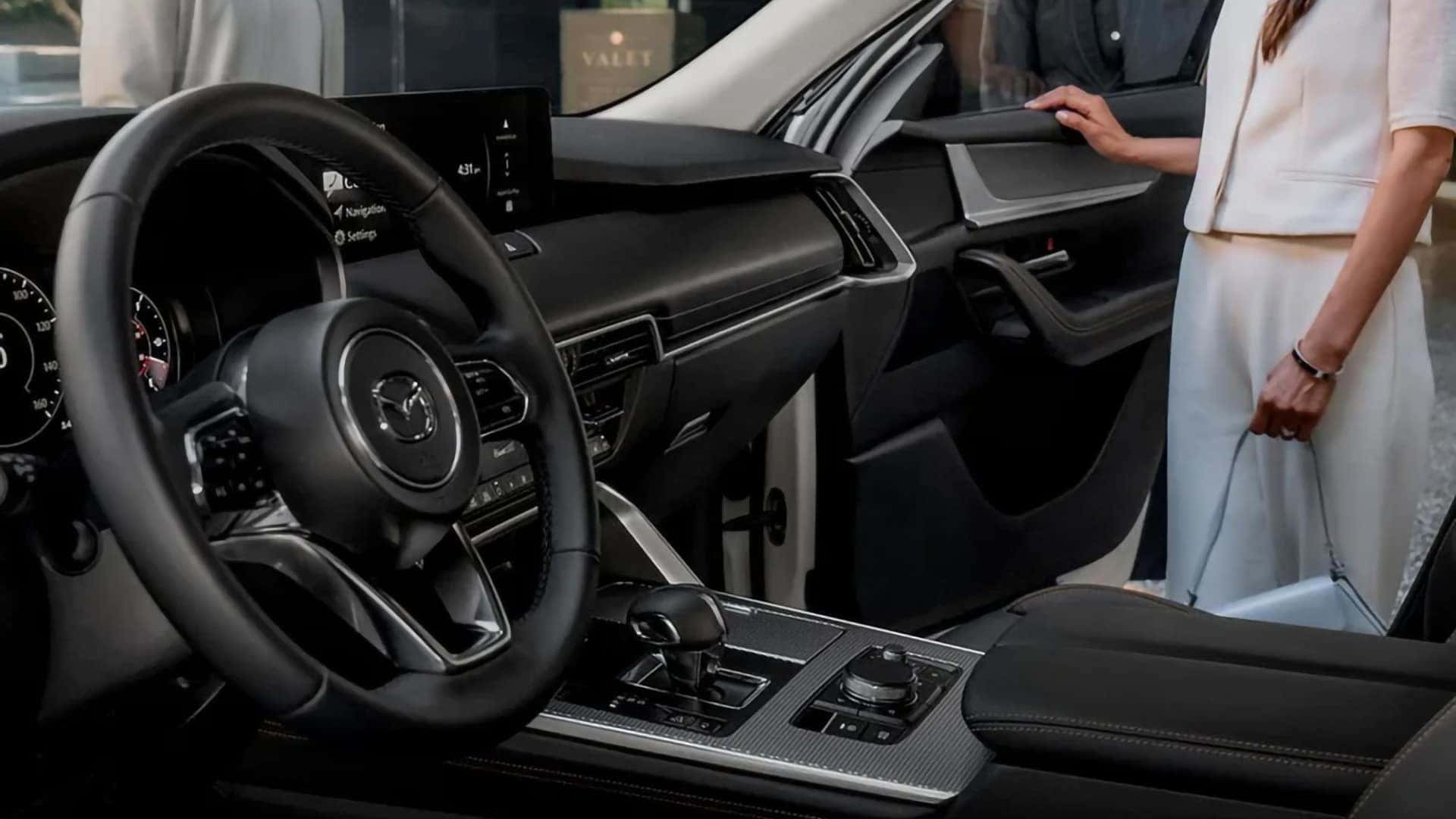 Driver-focused 2026 Mazda CX-70 PHEV cockpit with a wide dashboard, center display, and console controls