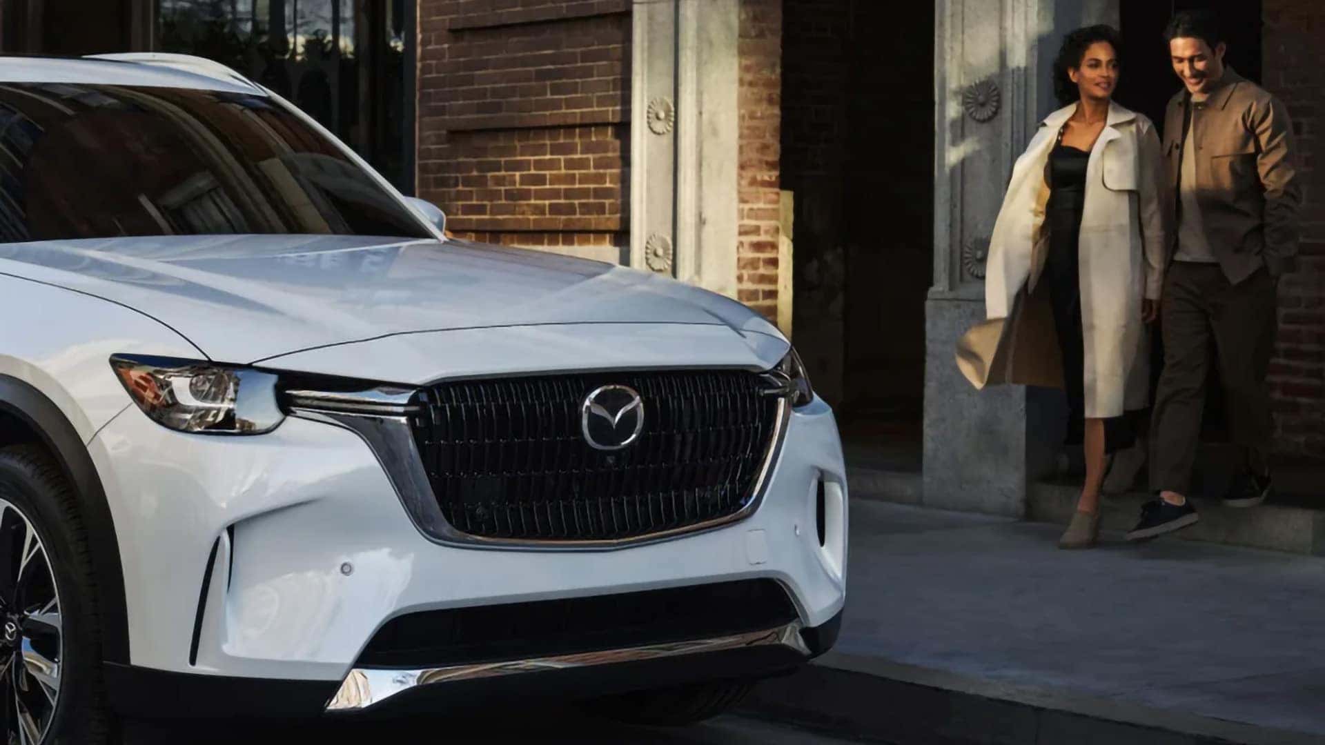 Front view of a white 2026 Mazda CX-90 PHEV showing its signature grille and Mazda emblem