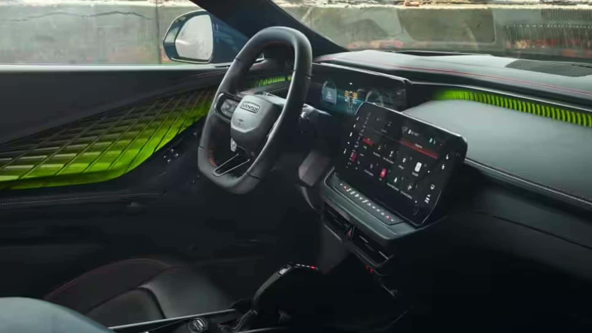 Dodge Charger cockpit with black steering wheel, digital displays, center touchscreen and bright green ambient lighting.