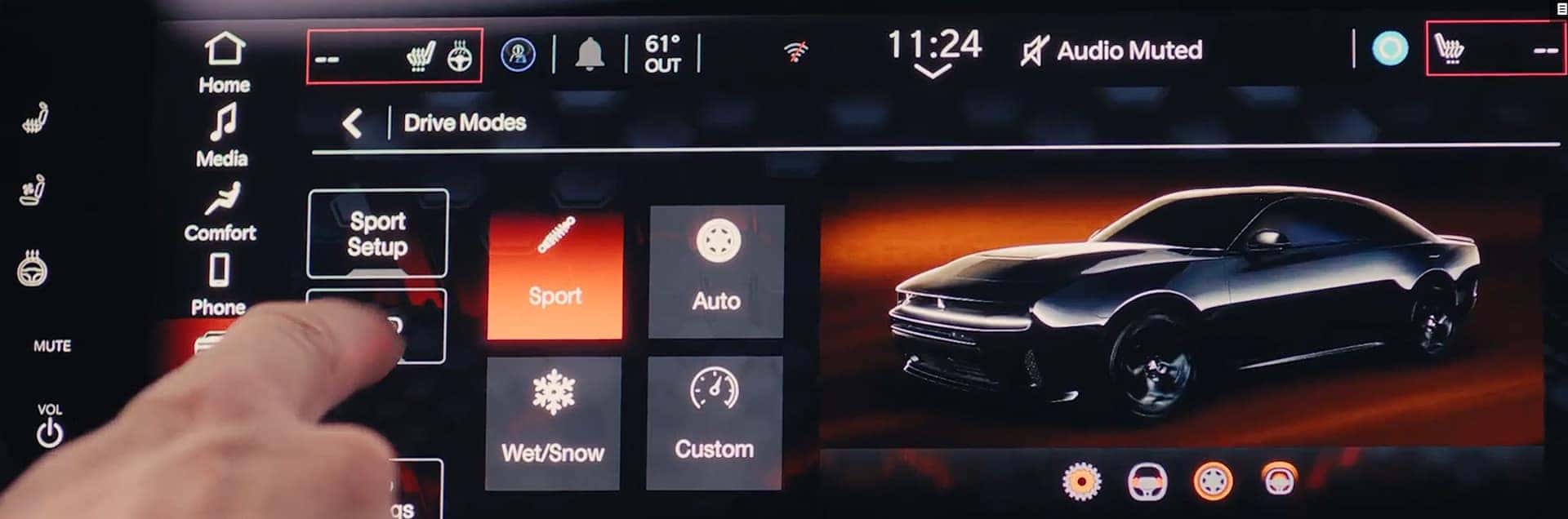 Hand touching Sport on a touchscreen Drive Modes menu with a black Charger graphic on the display.