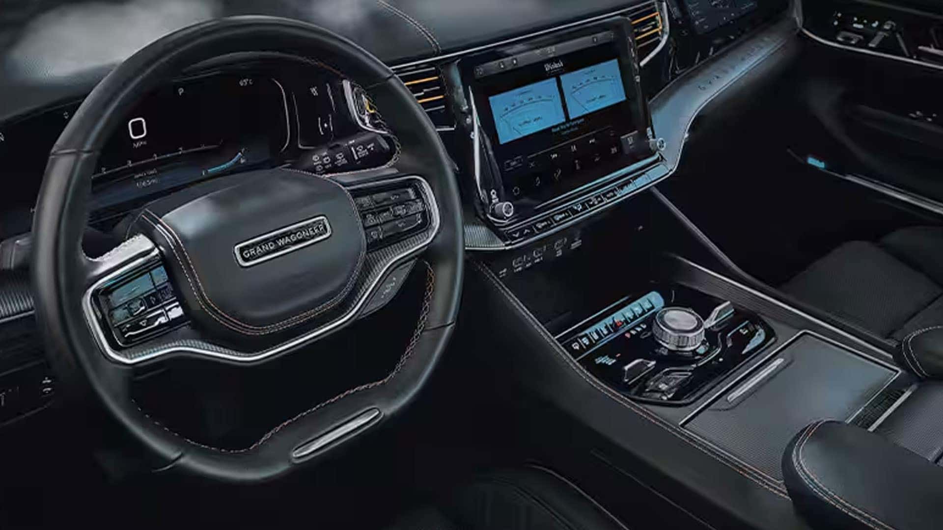 2026 Jeep Grand Wagoneer driver area with steering wheel, digital gauge cluster, center touchscreen and console controls.