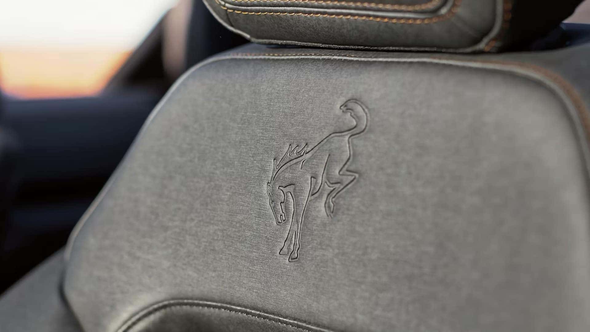 Close-up of a 2026 Ford Bronco front seat with an embossed Bronco emblem and contrast stitching
