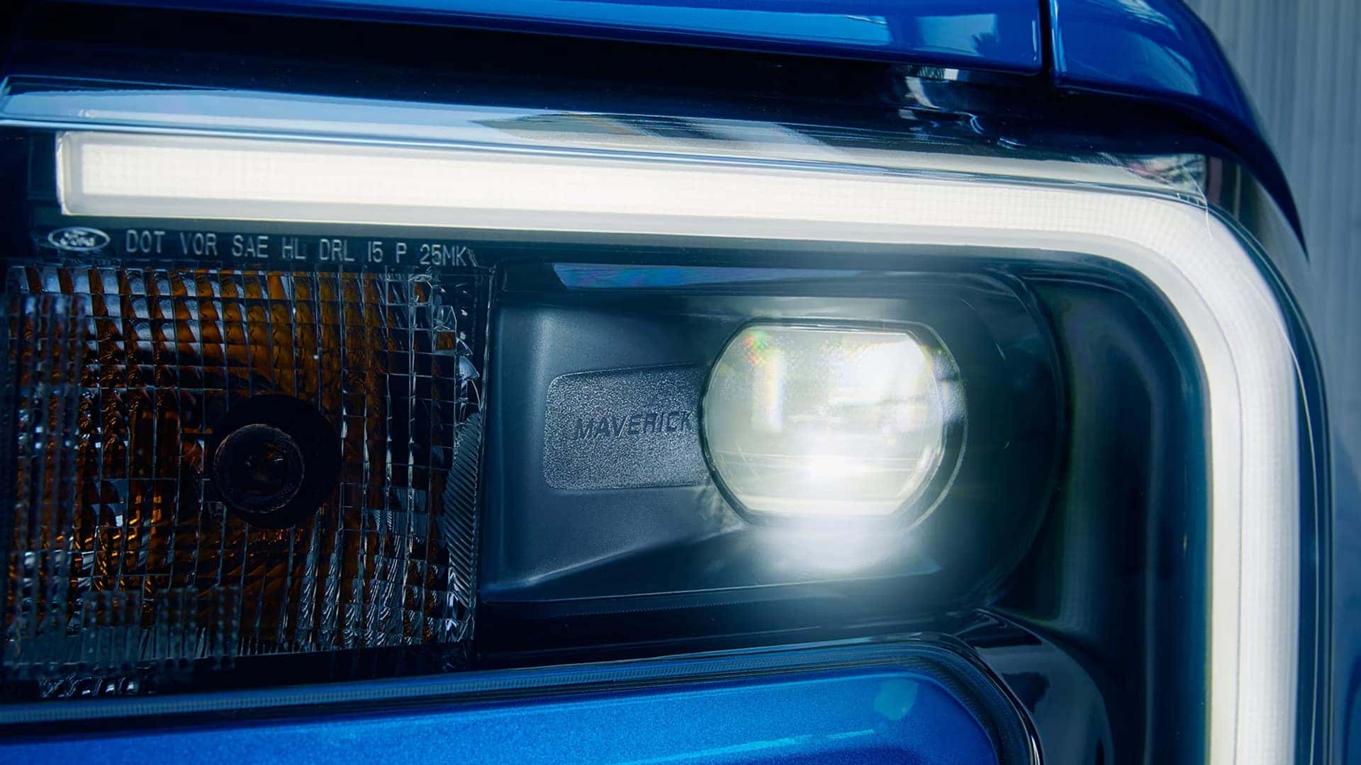 Illuminated headlamp and LED accent lighting on a blue 2026 Ford Maverick