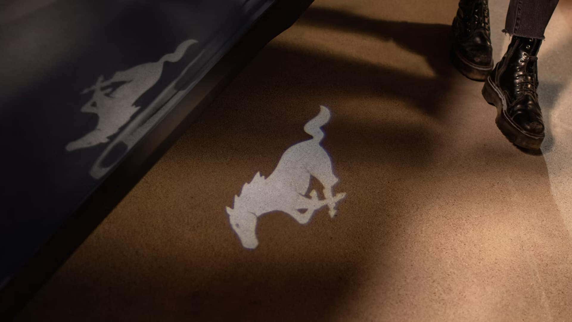 Mustang pony logo projected onto the ground by exterior puddle lighting