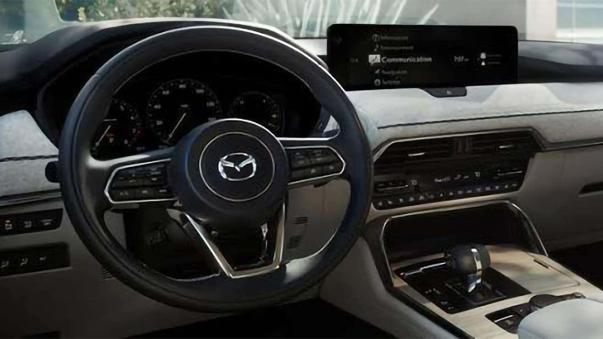 2026 Mazda CX-90 PHEV cockpit with Mazda steering wheel, driver gauges, and center display